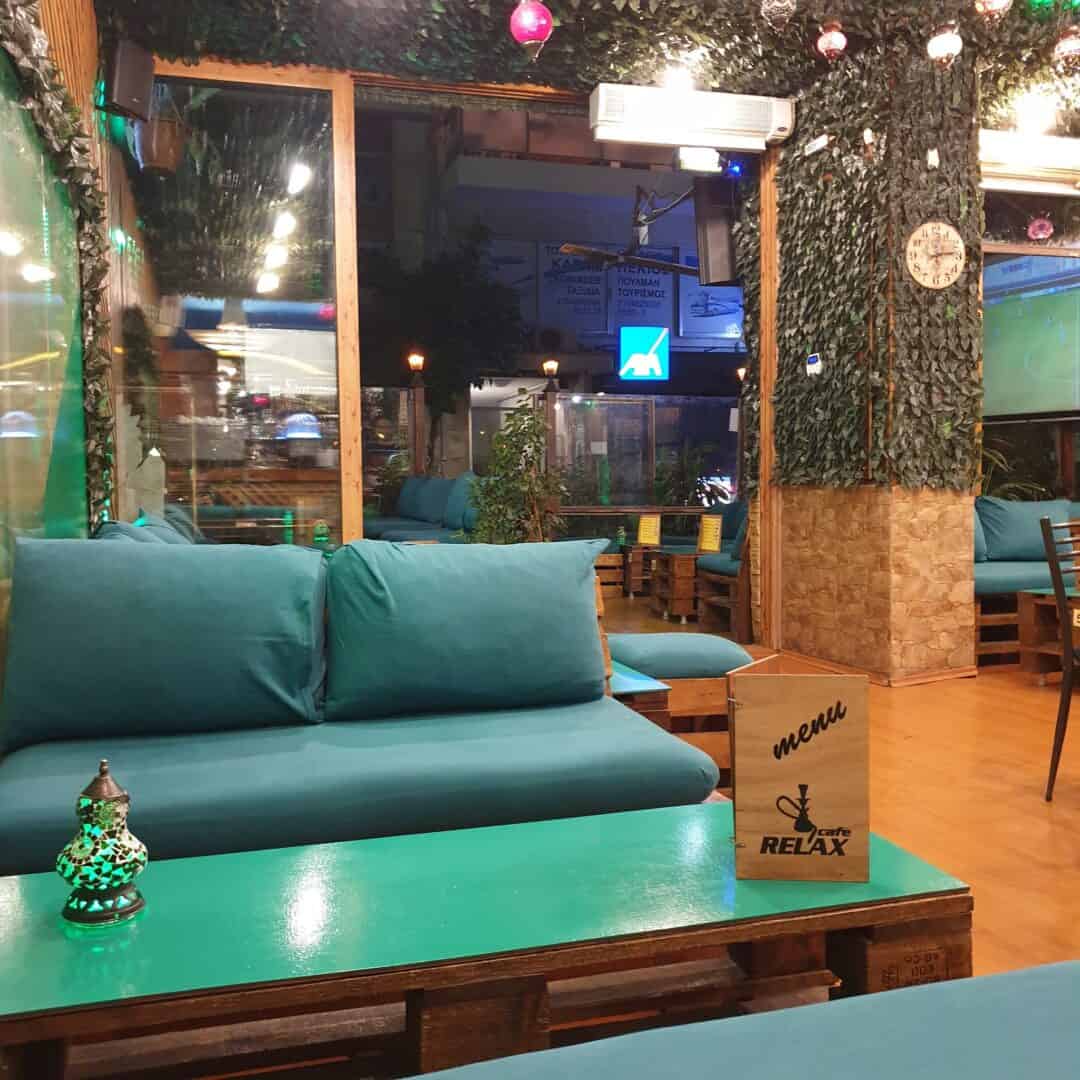 Cozy shisha lounge with teal sofas and ambient lighting at Relax Cafe.