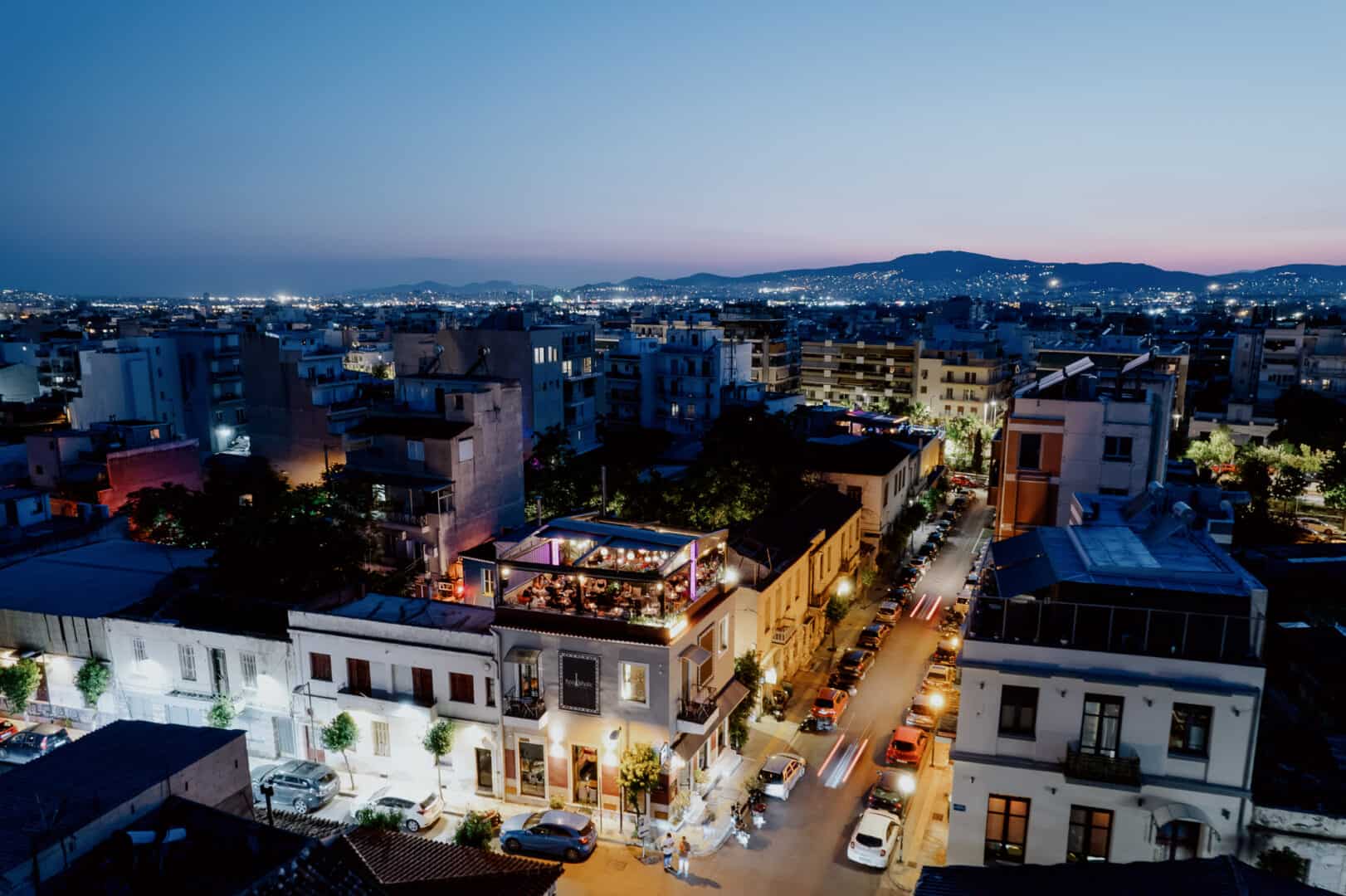 Night city view with illuminated buildings and streets in a vibrant urban area.