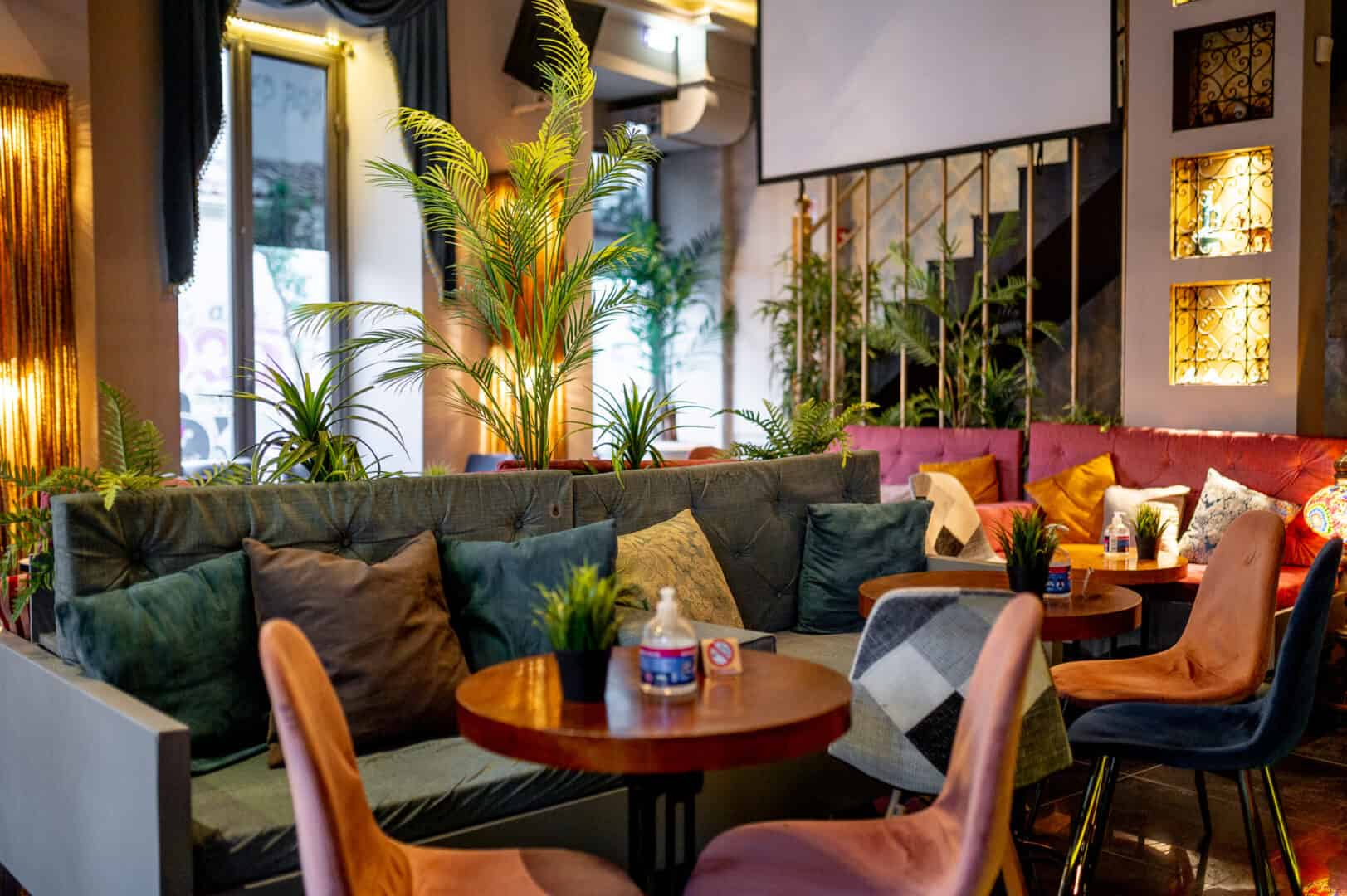 Stylish hookah lounge with cozy seating and lush plants at Shisha Break.